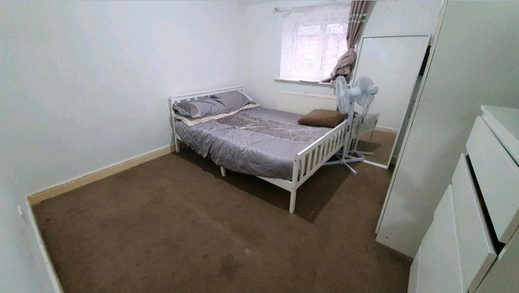Bright, simply furnished bedroom with a double ...