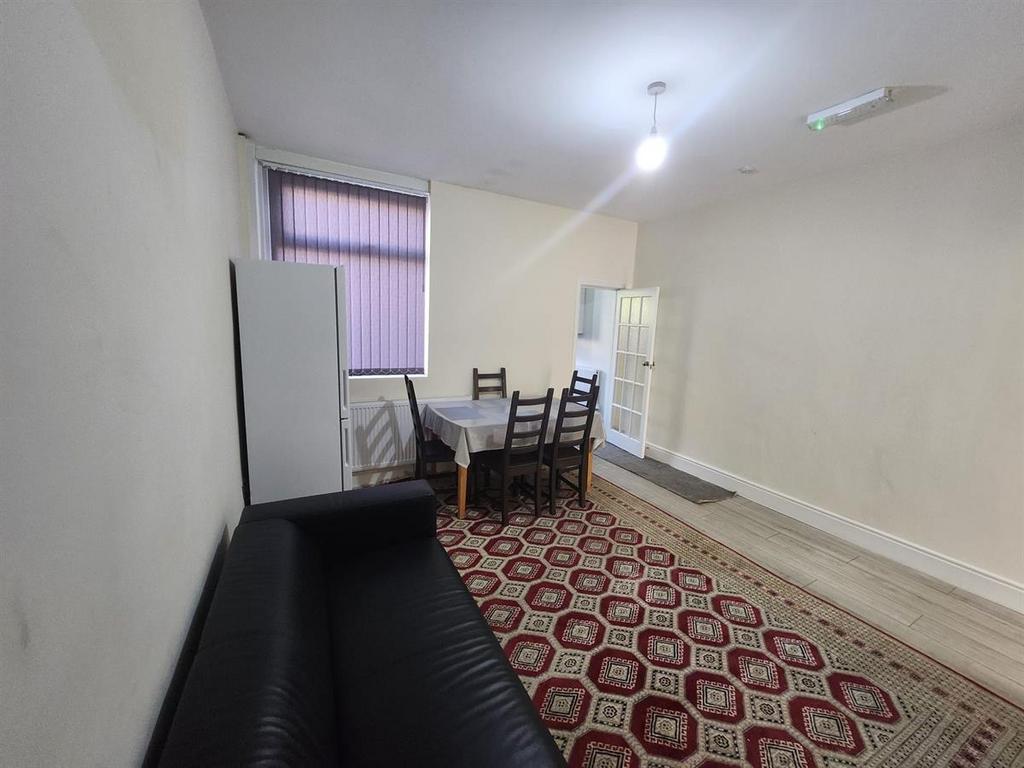 Bright communal lounge with a seating sofa, din...