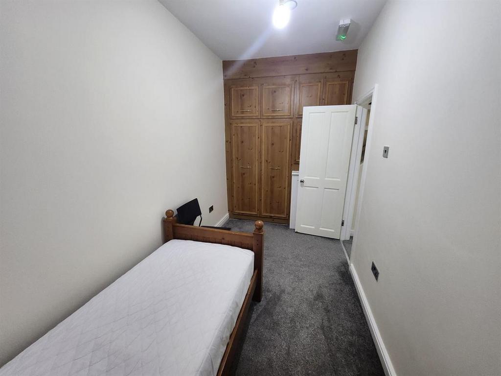 Neat single bedroom with built-in wooden wardro...