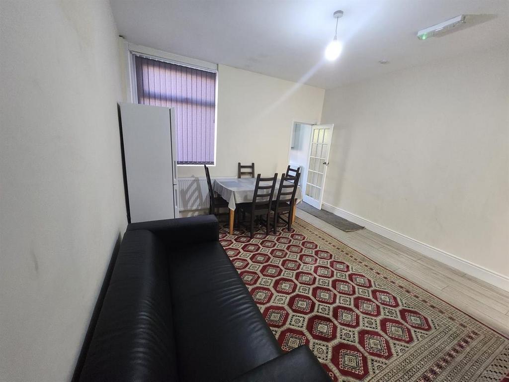Bright communal living room with a long sofa, d...