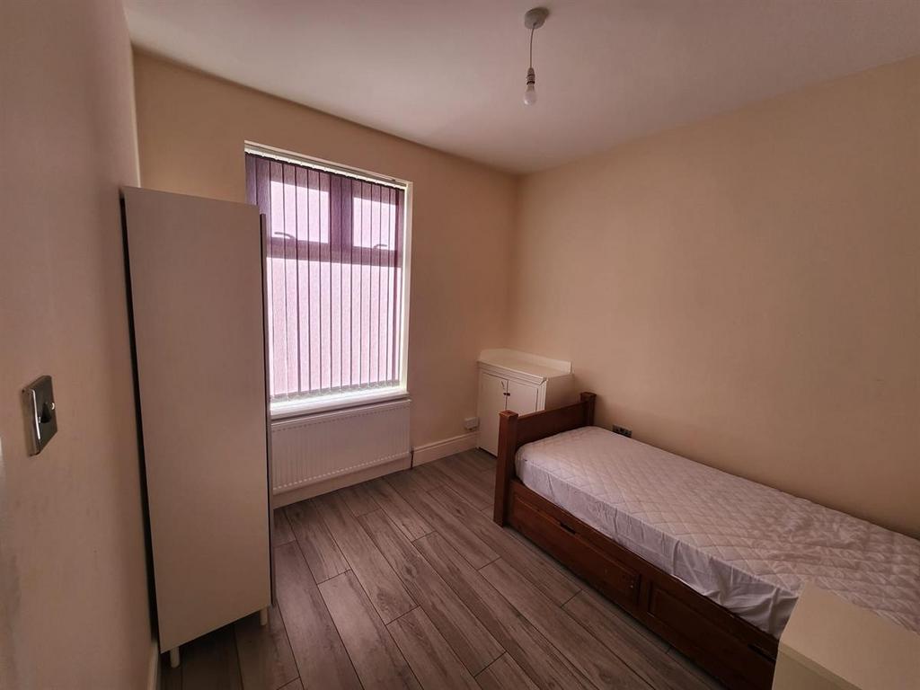Neat, simply furnished single bedroom with a la...