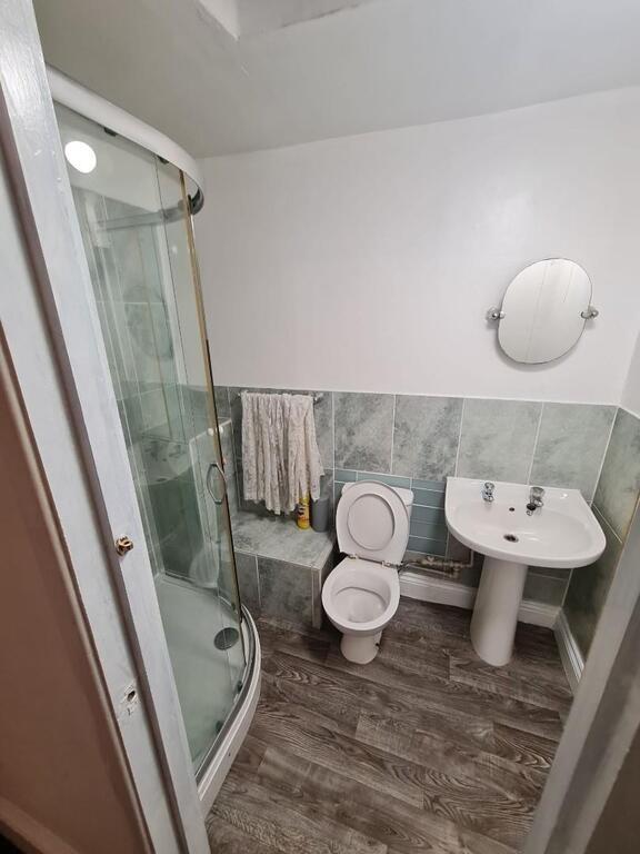 Clean, modern bathroom with a curved glass show...