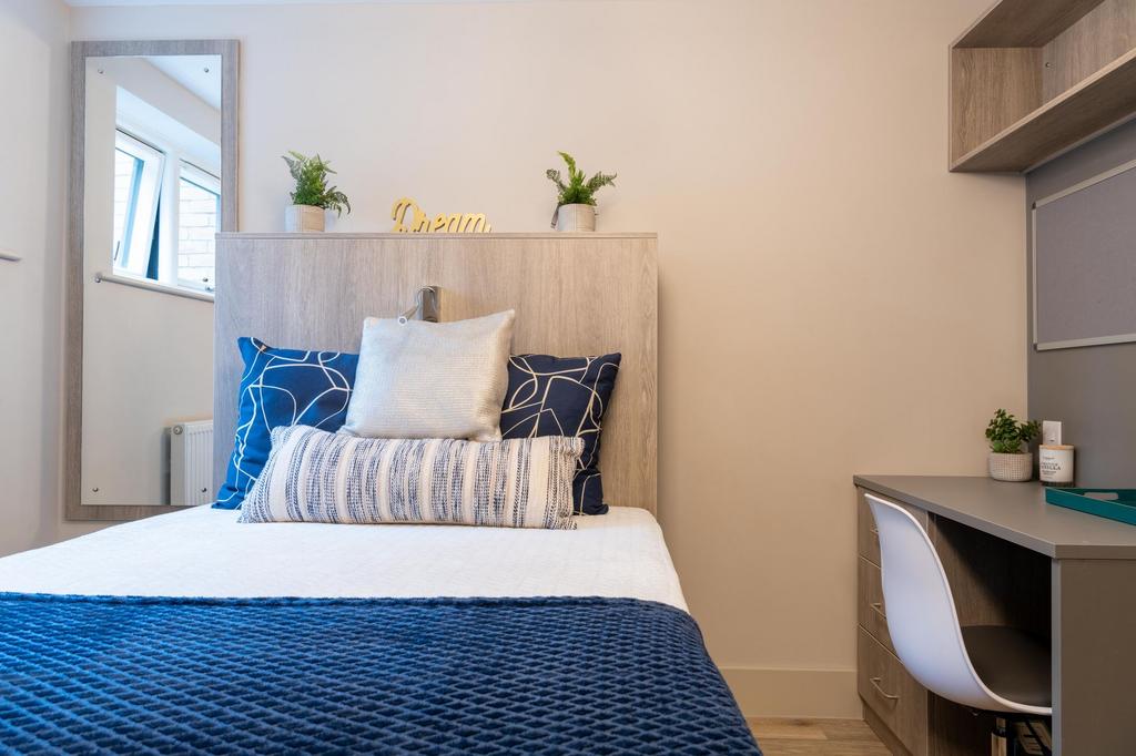 Bright, neatly styled single bedroom with a com...