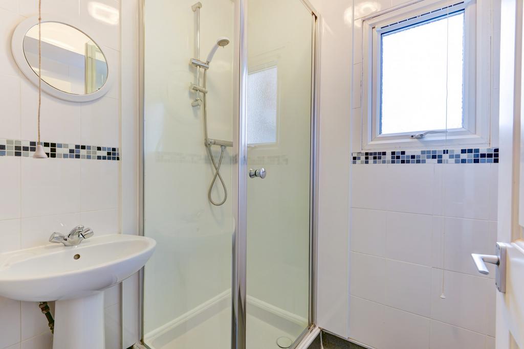 Bright, modern bathroom with a clear glass show...