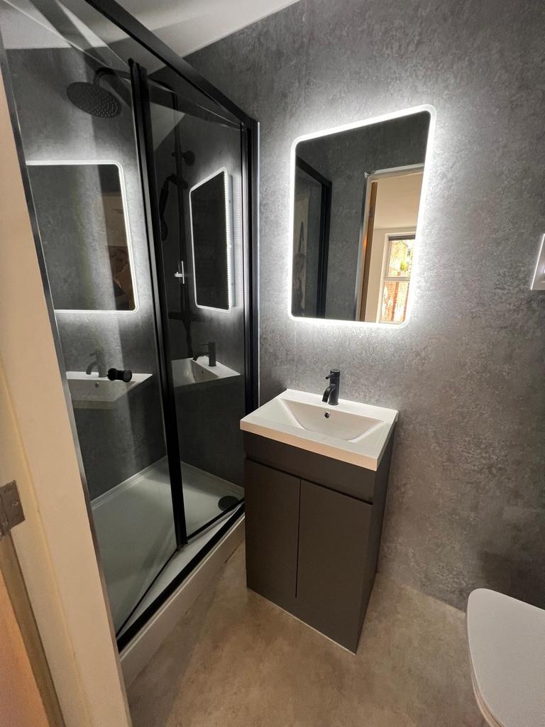 Modern bathroom with a walk-in shower, backlit ...