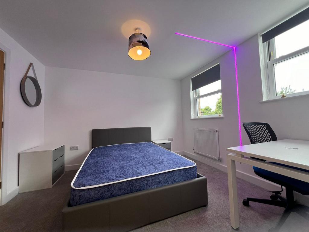 Bright, modern bedroom with a comfortable uphol...