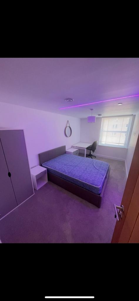 Bright, modern double bedroom with a comfortabl...