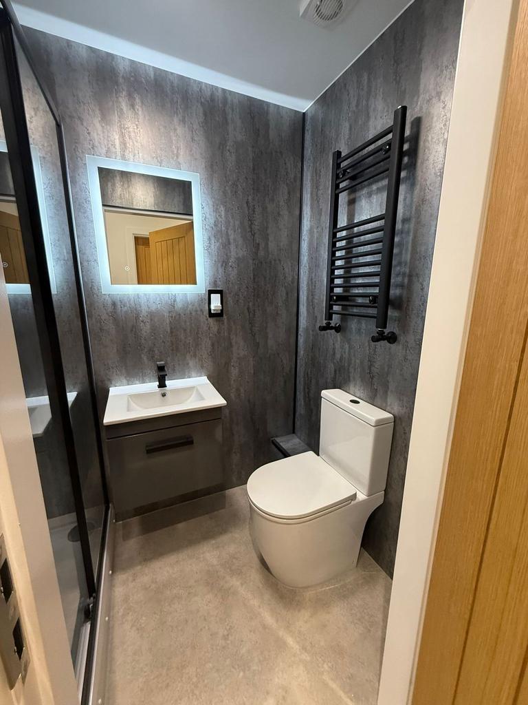 Modern ensuite bathroom with a wall-mounted van...