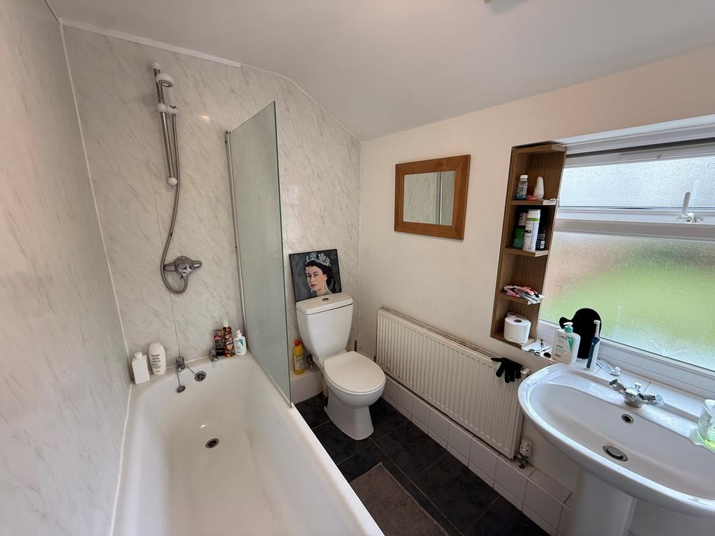 Bright, well-maintained bathroom with a bath an...