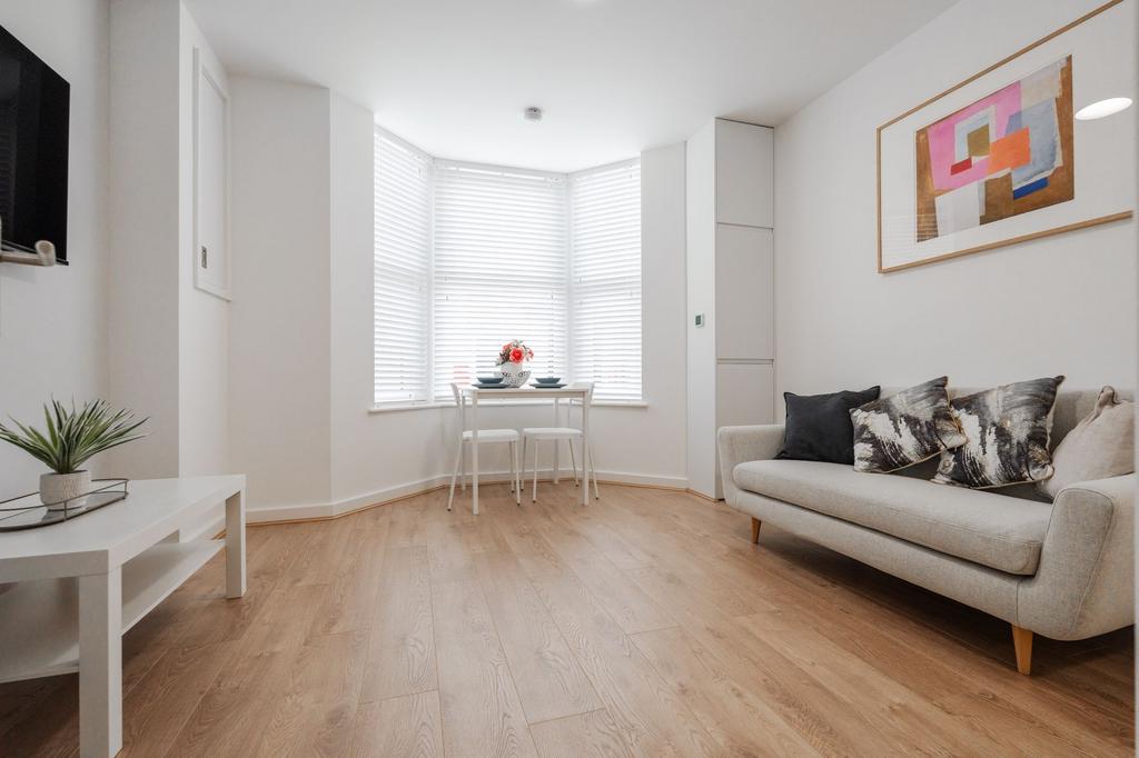 Bright and spacious living room featuring large...