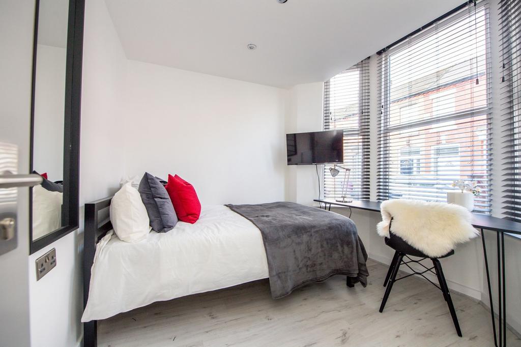 A modern and bright bedroom featuring a large b...