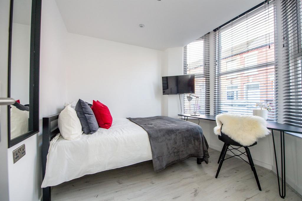Bright and modern master bedroom featuring a co...