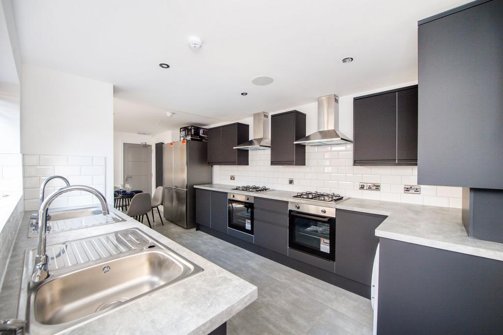 Modern galley kitchen with sleek dark cabinetry...