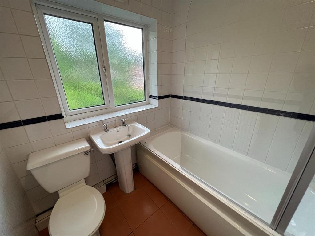 Bright, well-maintained bathroom with a white b...