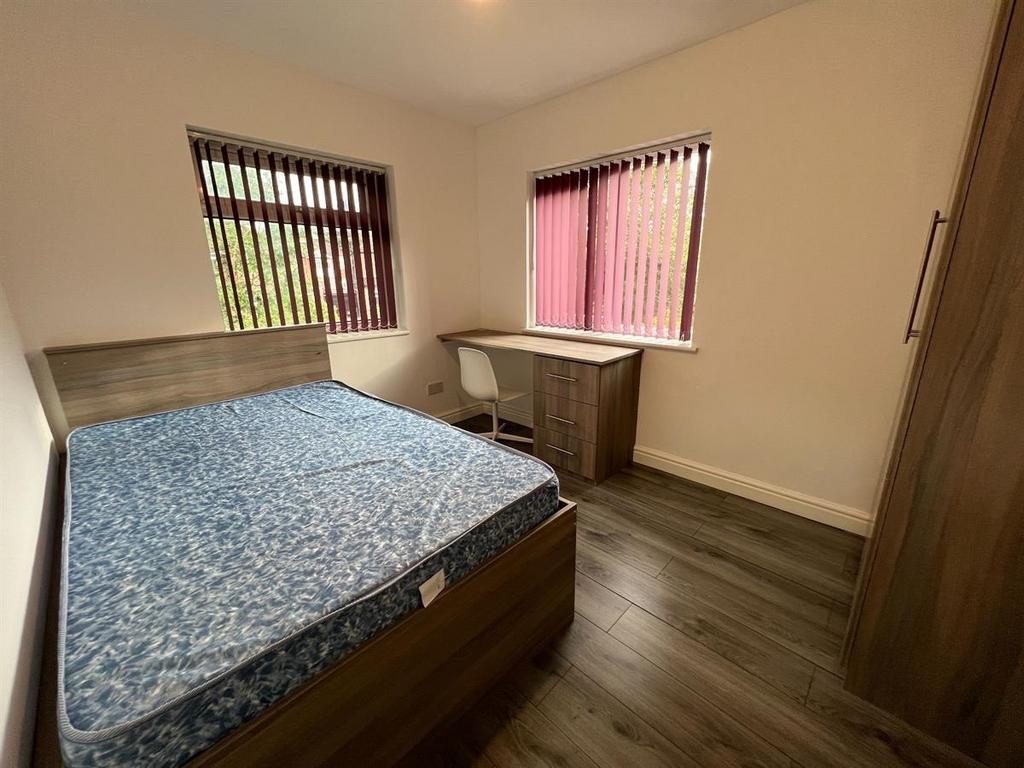 Neat furnished bedroom with a double bed, wardr...