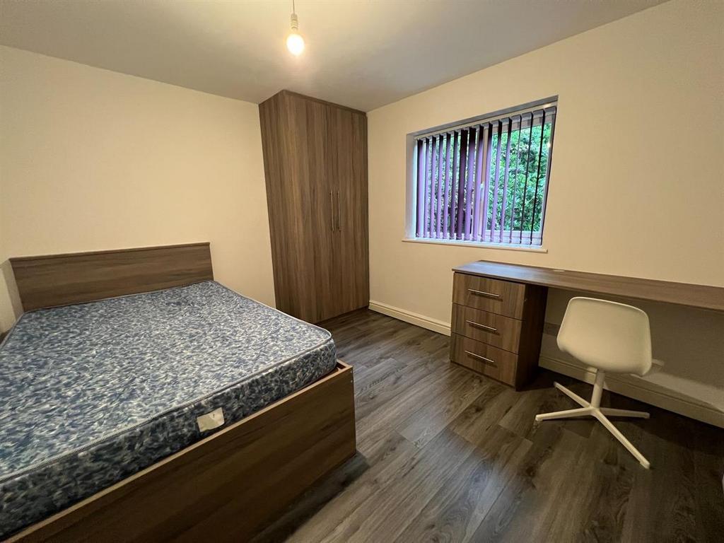 Bright, tidy bedroom with wooden flooring, fitt...