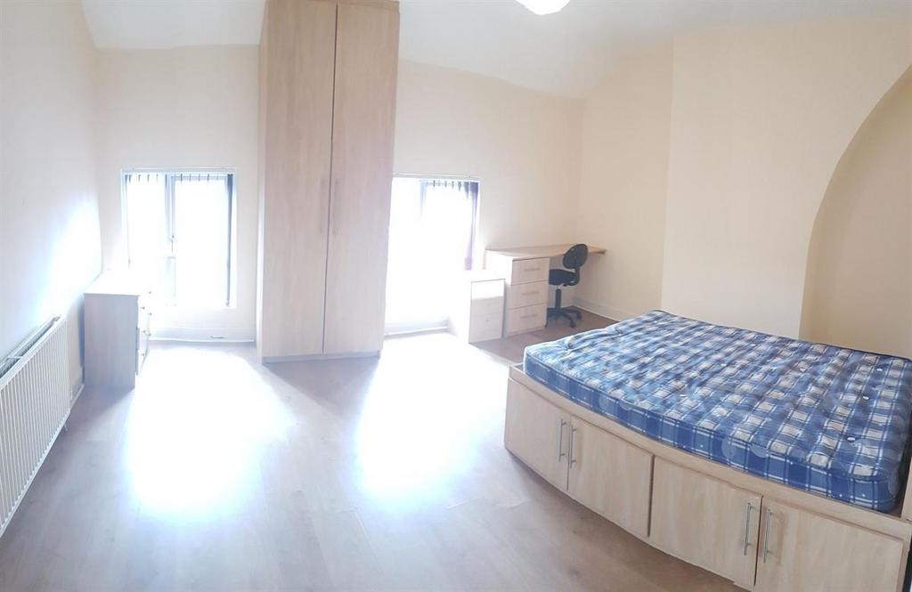 Bright, airy bedroom with large windows, built-...
