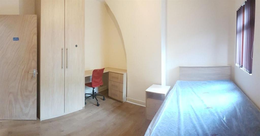 Bright, simply furnished bedroom with a single ...