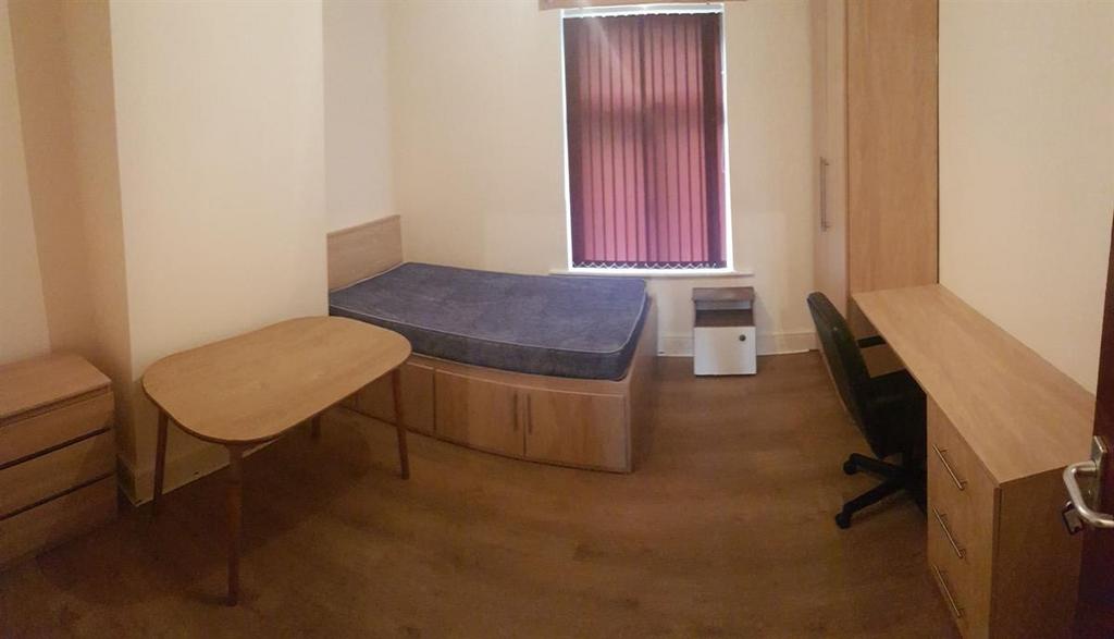Simple, well-kept single bedroom with wooden fl...
