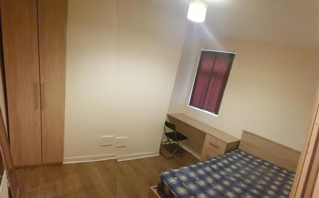 Simple, well-kept single bedroom with wood-effe...