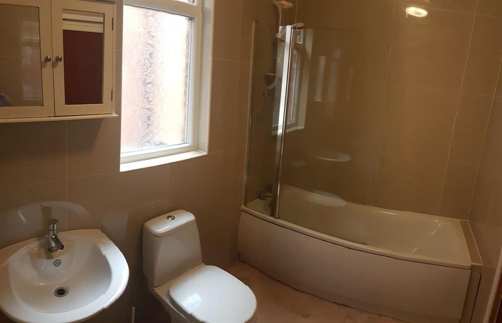 Bright, modern bathroom with a curved shower-ba...