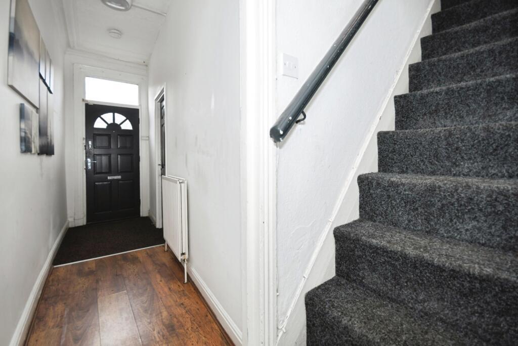 Bright entrance hallway with wooden flooring, a...