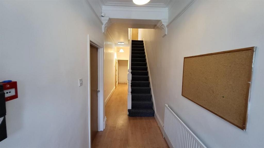 Bright, neutral hallway with wooden flooring, a...