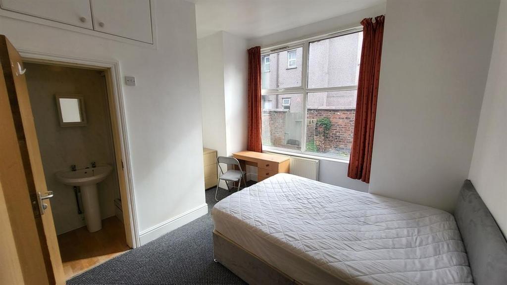 Bright, simply furnished bedroom with a large w...