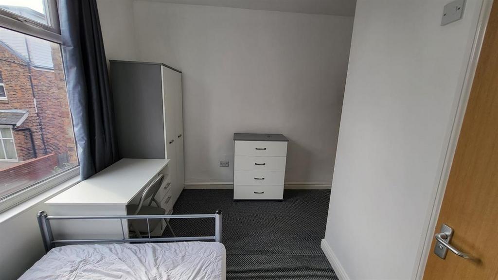 Bright, simply furnished bedroom with a single ...