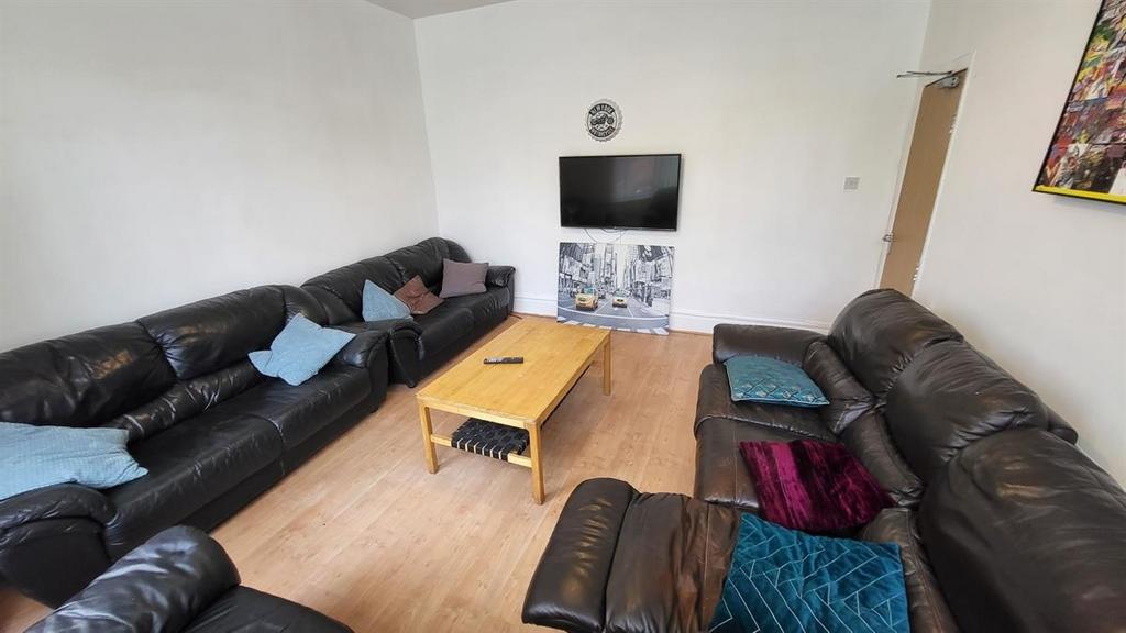 Spacious communal lounge with multiple comforta...