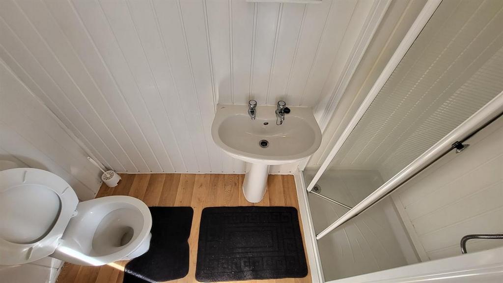 Compact, clean bathroom with a pedestal sink, t...
