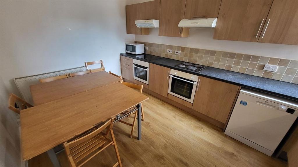 Bright fitted kitchen with wood-effect cabinets...