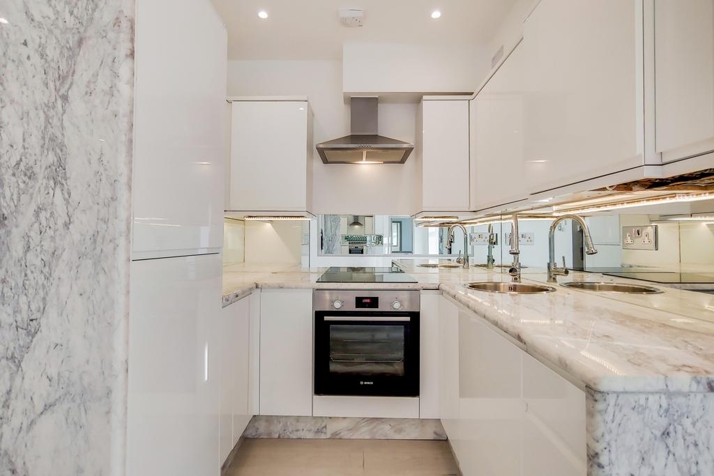 Bright, modern kitchen with glossy white cabine...