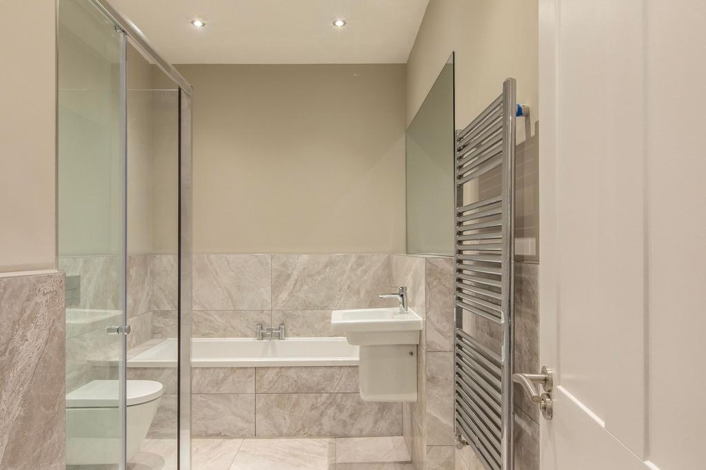 Modern neutral-toned bathroom with a built-in b...