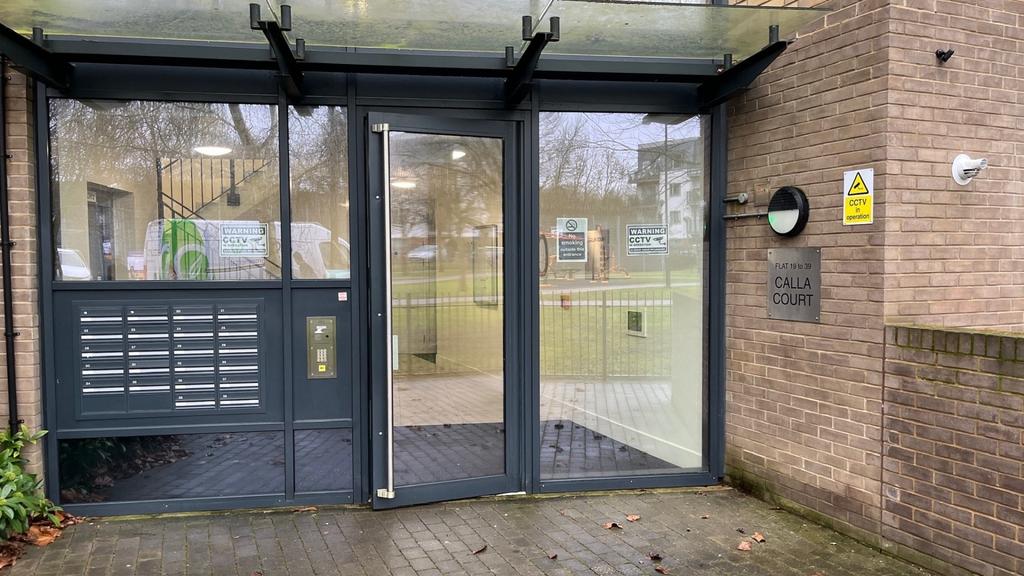 Secure glass-fronted entrance with a row of par...
