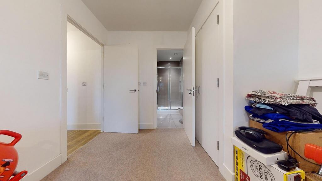 Bright, neutral hallway with light carpet, whit...