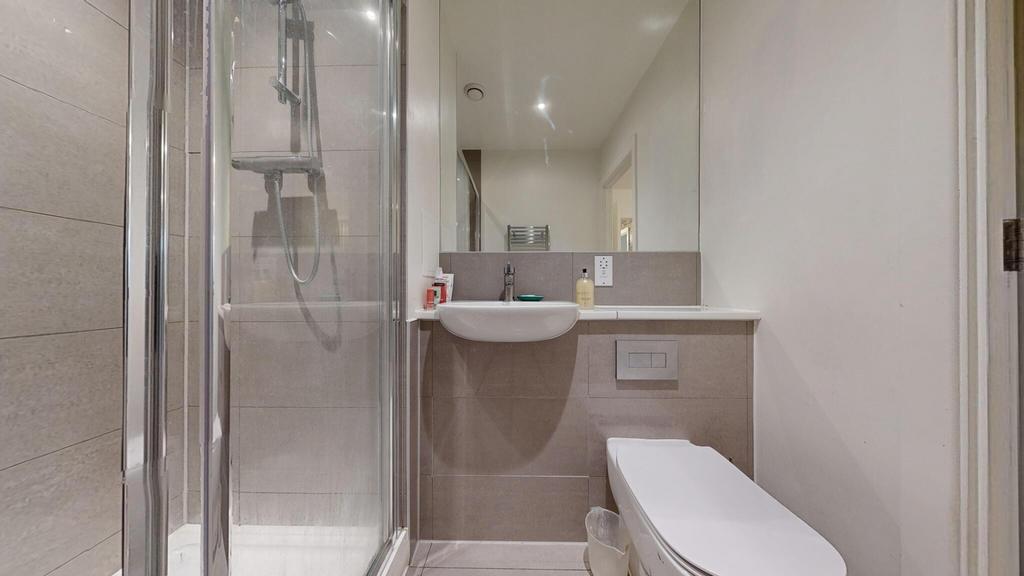 Modern bathroom with a glass-enclosed shower, w...