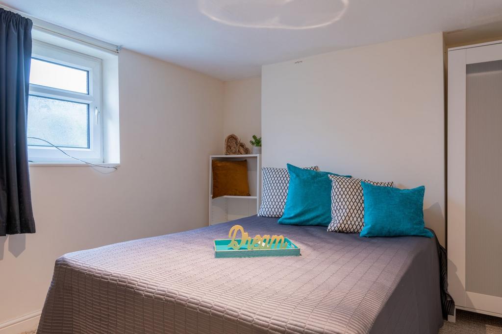 Bright, neatly styled bedroom with a comfortabl...