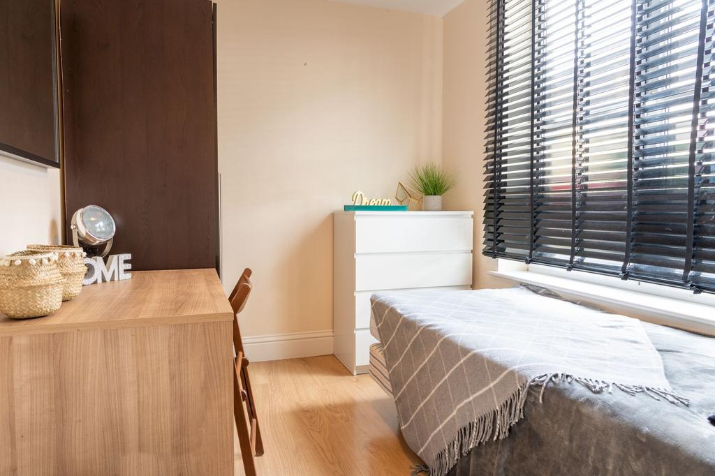 Bright, tidy bedroom with a neatly made single ...
