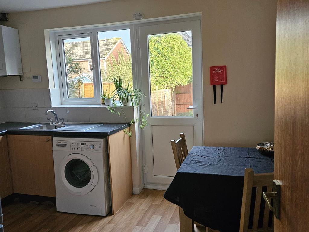 Bright kitchen with a large window and back doo...