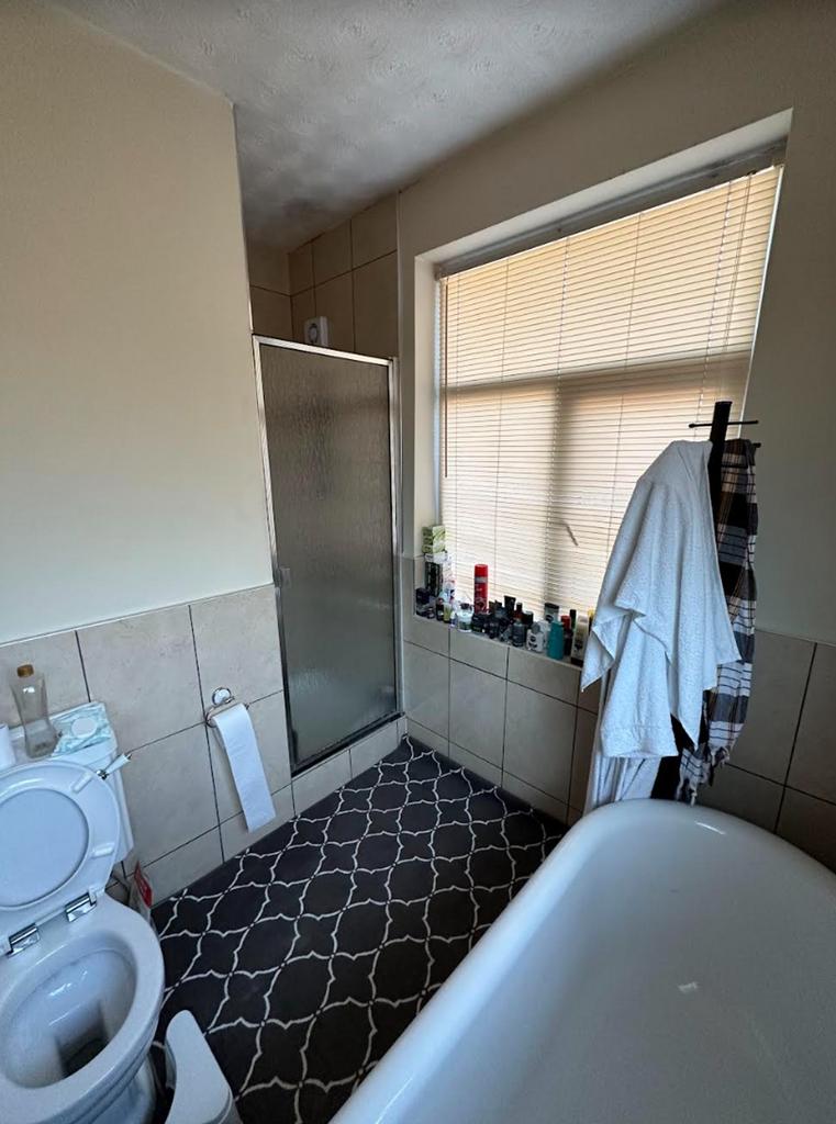 A spacious and bright bathroom featuring a show...