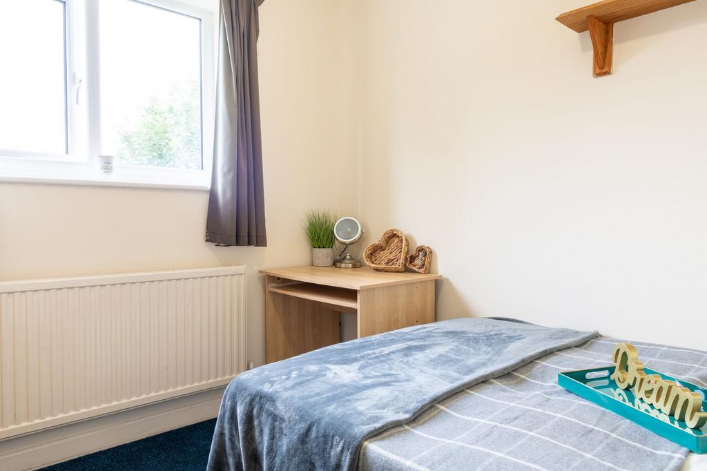 Bright, simply furnished single bedroom with a ...