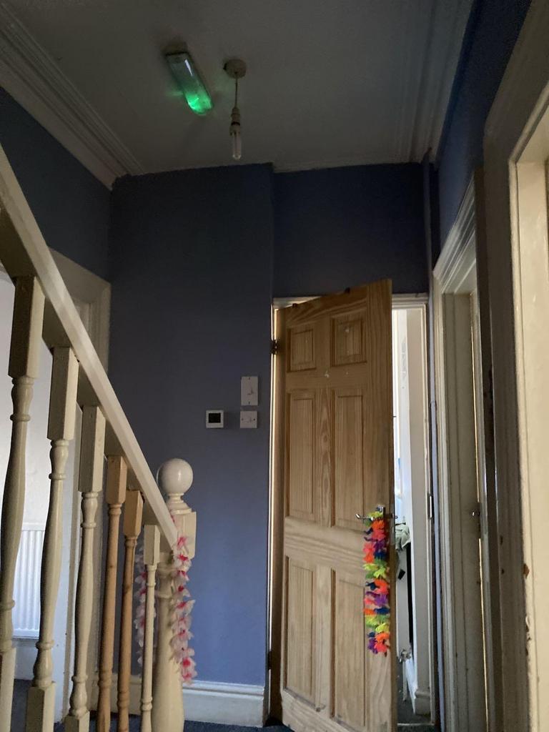 Bright hallway with painted walls, turned wood ...