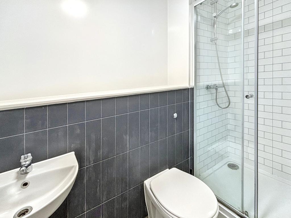Modern bathroom with glass-enclosed shower, whi...