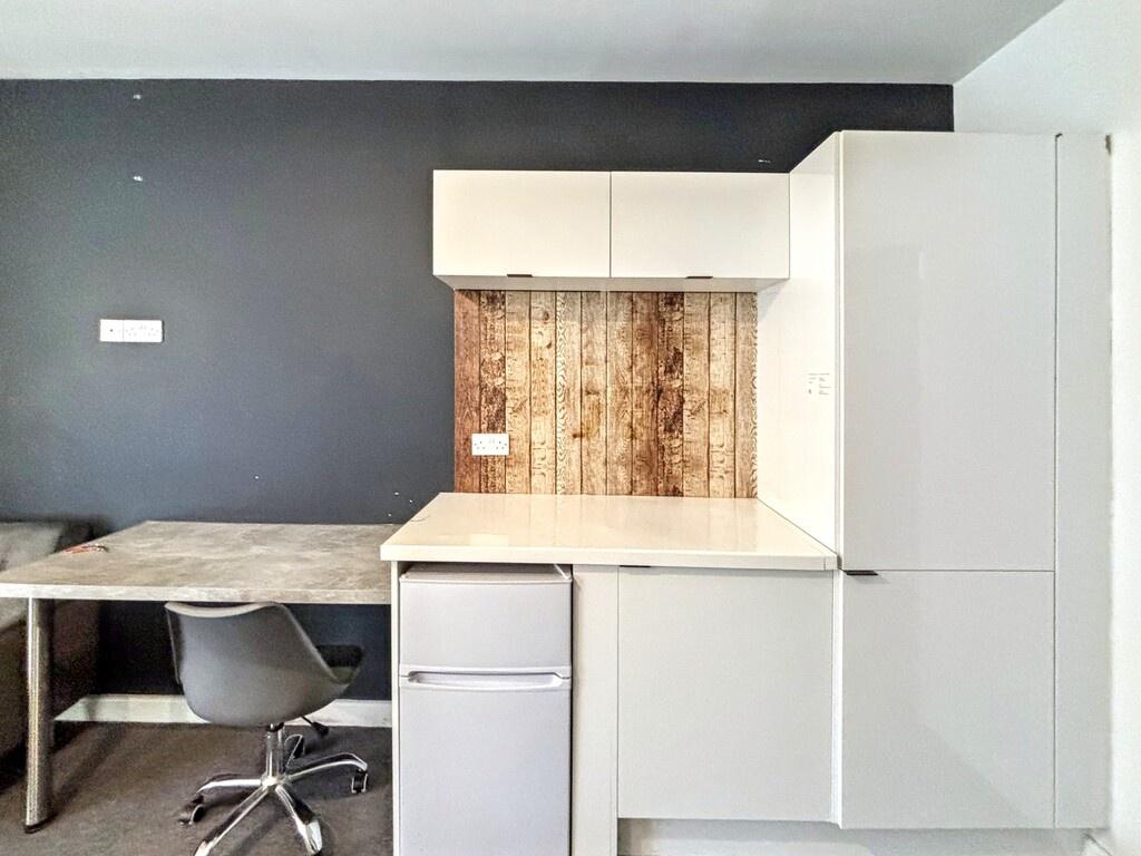 Bright compact kitchen area with integrated whi...