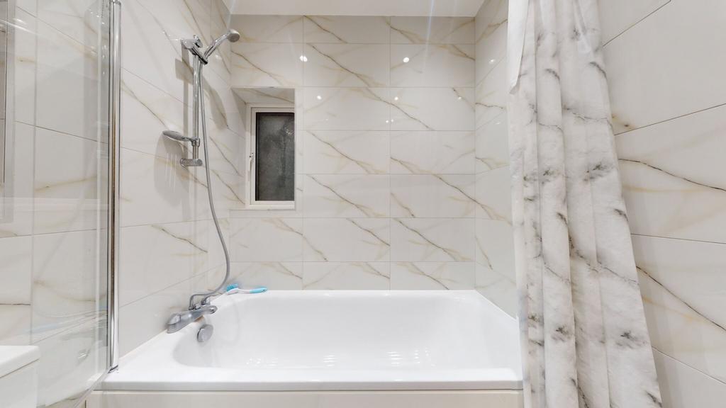 Bright, modern bathroom with a full-size bathtu...