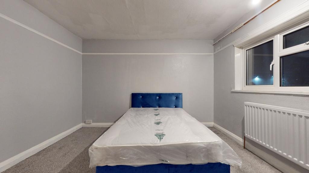 Neat, simply furnished bedroom with a comfortab...