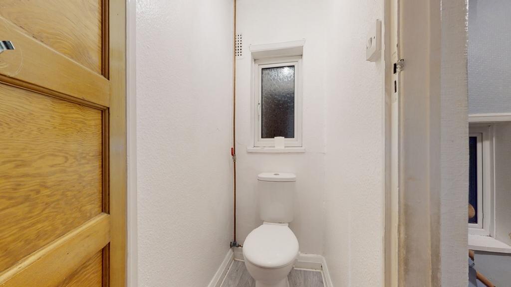 Compact, freshly painted WC with a modern close...