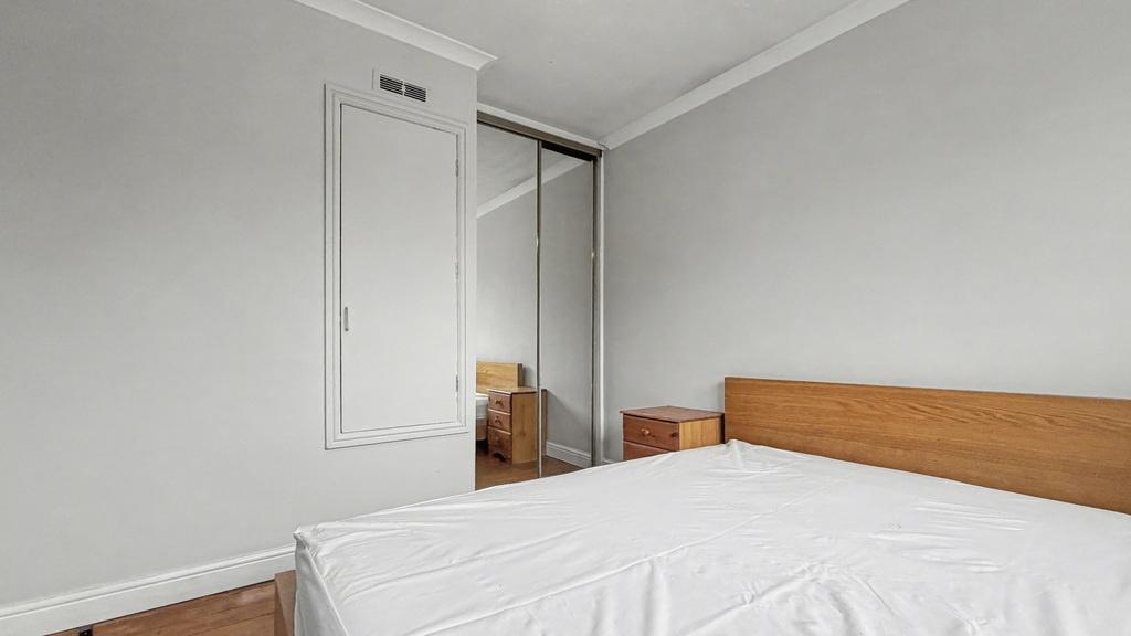 Bright, simply furnished bedroom with a double ...
