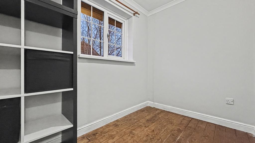 Compact bedroom with a tall shelving unit, fres...